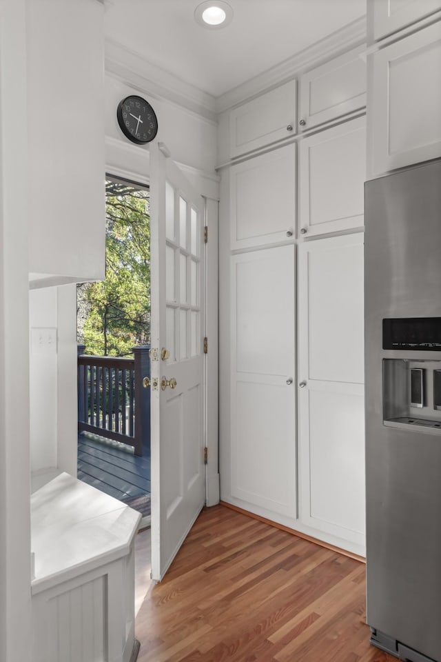 interior space with light hardwood / wood-style floors and ornamental molding