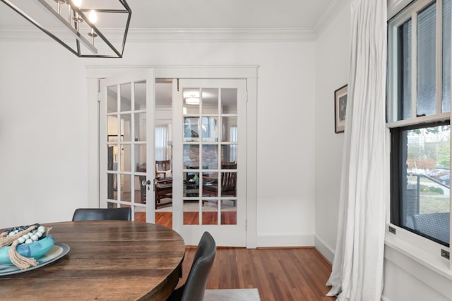 unfurnished dining area featuring french doors, hardwood / wood-style flooring, and ornamental molding