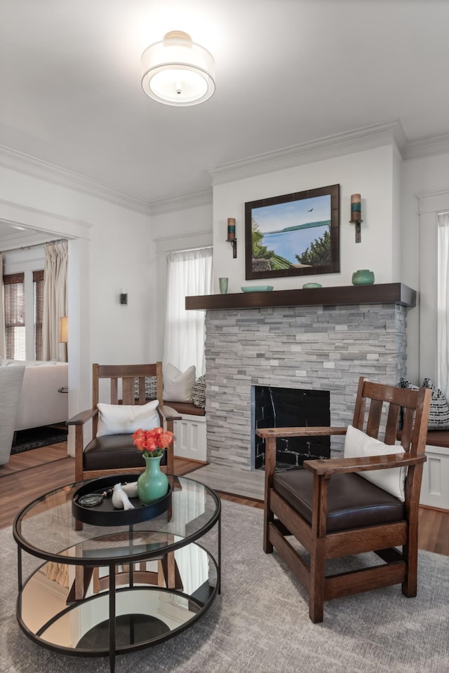 living room with a fireplace, crown molding, and light hardwood / wood-style flooring