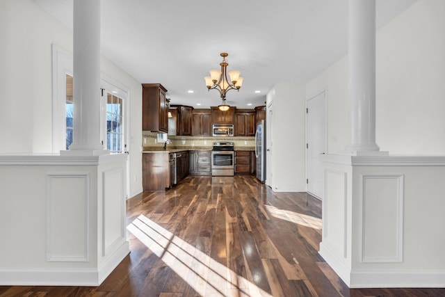 kitchen with an inviting chandelier, appliances with stainless steel finishes, dark hardwood / wood-style floors, dark brown cabinets, and sink