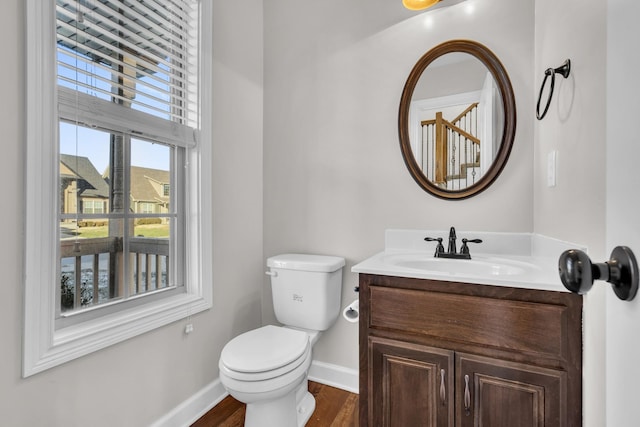 bathroom with toilet, vanity, and hardwood / wood-style floors