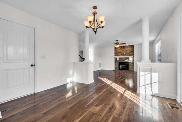 unfurnished living room with ceiling fan with notable chandelier, a fireplace, and dark hardwood / wood-style floors