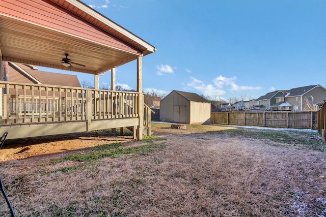 view of yard with ceiling fan, a storage unit, and a wooden deck