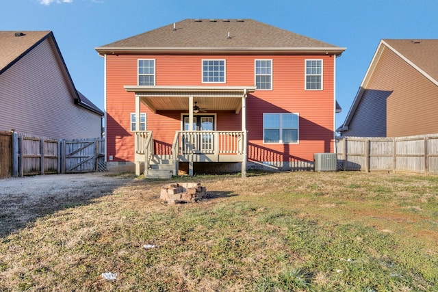 rear view of property featuring a deck, central AC, and a yard