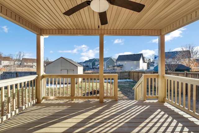 wooden deck featuring ceiling fan and an outdoor structure