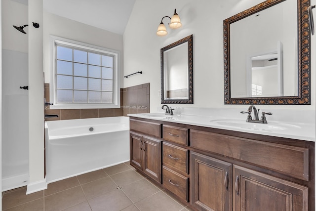 bathroom featuring vaulted ceiling, a tub to relax in, vanity, and tile patterned flooring