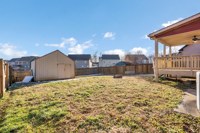 view of yard with ceiling fan and a storage unit