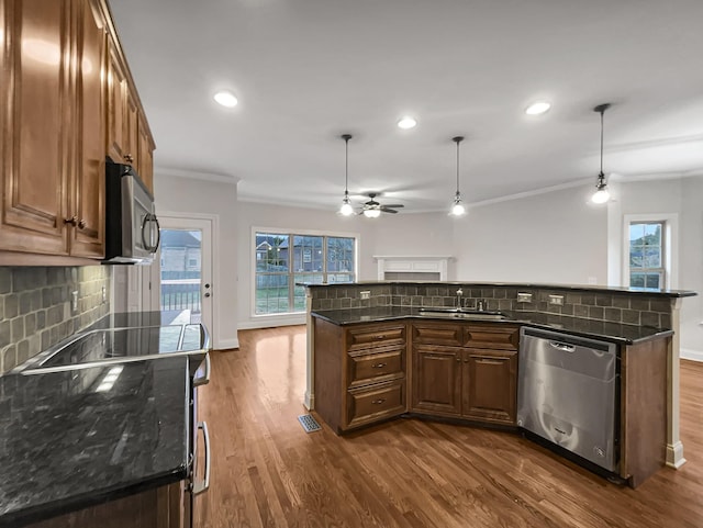 kitchen featuring decorative backsplash, pendant lighting, stainless steel appliances, and crown molding