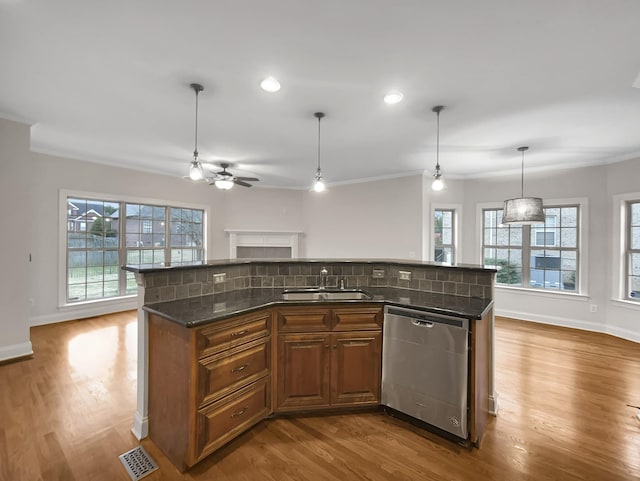 kitchen with sink, tasteful backsplash, stainless steel dishwasher, an island with sink, and decorative light fixtures