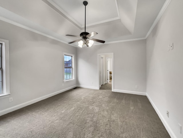 unfurnished room featuring a wealth of natural light, a raised ceiling, dark carpet, and ceiling fan