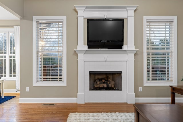 living room featuring hardwood / wood-style floors and a tiled fireplace