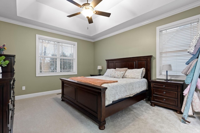 carpeted bedroom with a raised ceiling, ceiling fan, and ornamental molding