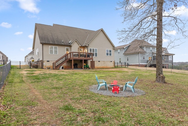 rear view of house with a yard, a fire pit, and a deck