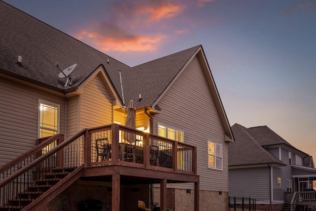 back house at dusk with a wooden deck