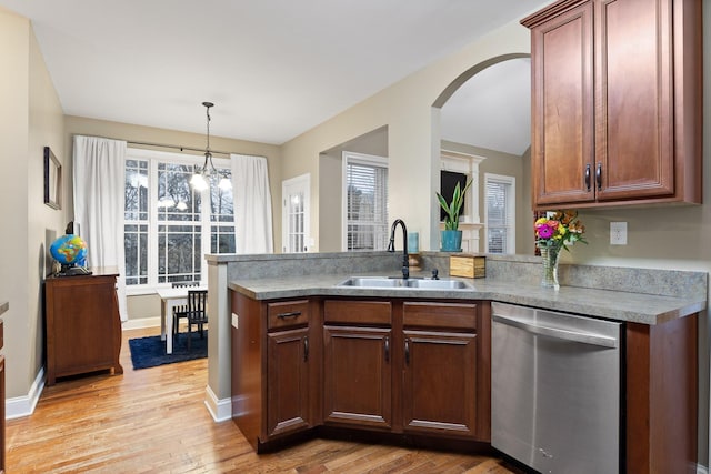 kitchen with sink, light hardwood / wood-style flooring, stainless steel dishwasher, a notable chandelier, and kitchen peninsula