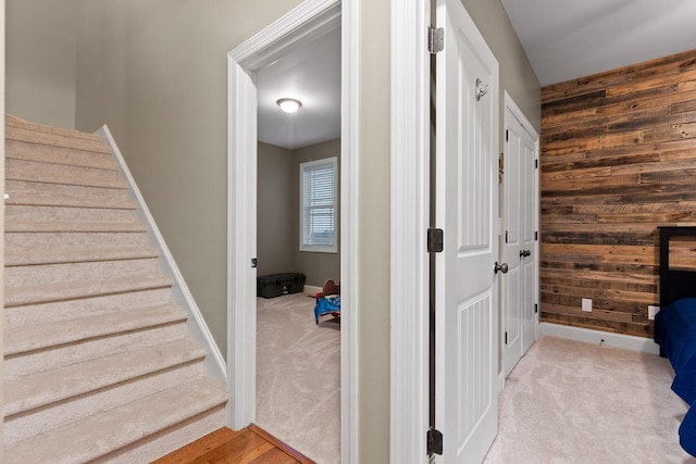 staircase with carpet flooring and wooden walls