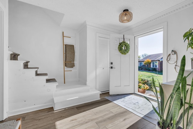 entrance foyer featuring crown molding, a textured ceiling, and hardwood / wood-style flooring