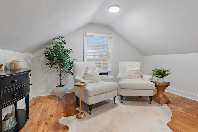 living area featuring hardwood / wood-style flooring and vaulted ceiling