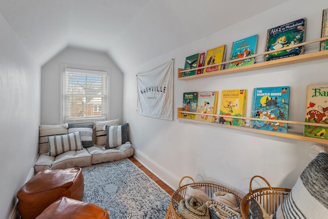 sitting room with vaulted ceiling and wood-type flooring