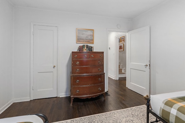 bedroom with dark hardwood / wood-style floors and ornamental molding