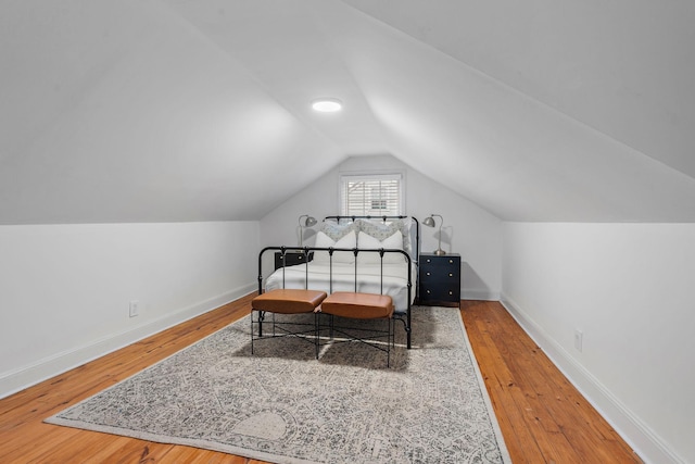 bedroom featuring hardwood / wood-style flooring and vaulted ceiling