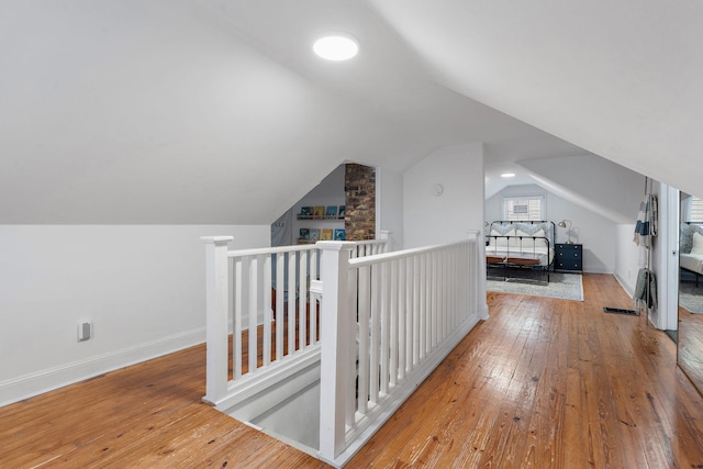 bonus room with light wood-type flooring and lofted ceiling