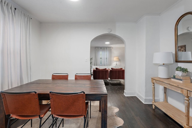 dining room with ornamental molding and dark hardwood / wood-style flooring