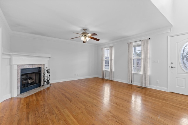 unfurnished living room featuring ceiling fan, ornamental molding, a fireplace, and light hardwood / wood-style flooring