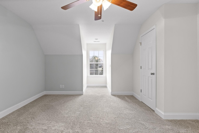 additional living space with ceiling fan, light colored carpet, and vaulted ceiling