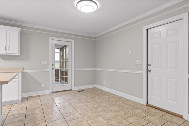 unfurnished dining area with light tile patterned floors and ornamental molding