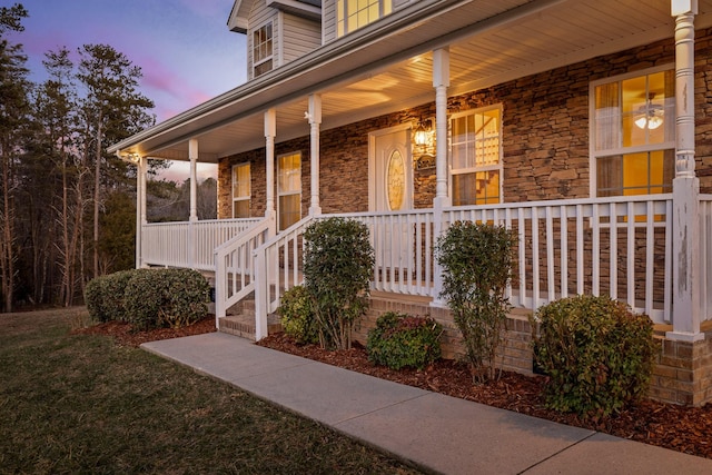 exterior entry at dusk with covered porch