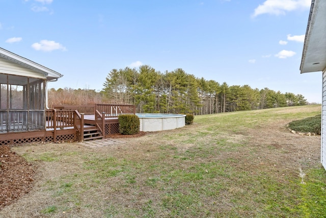 view of yard with a sunroom and a swimming pool side deck