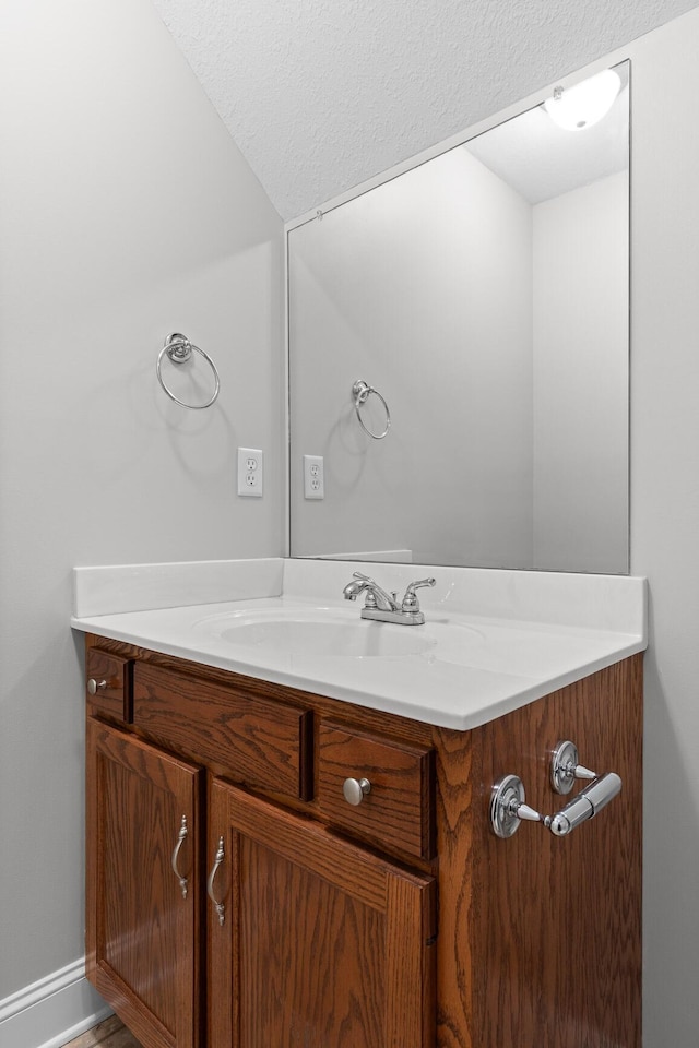 bathroom featuring a textured ceiling and vanity