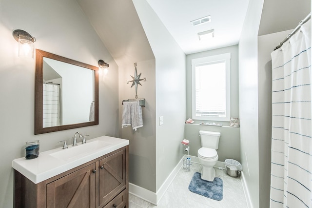 bathroom featuring vanity, lofted ceiling, and toilet