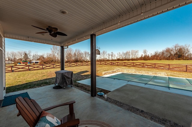 view of patio / terrace with ceiling fan, area for grilling, and a rural view