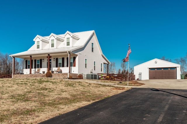 new england style home with a porch, a garage, central air condition unit, and an outbuilding