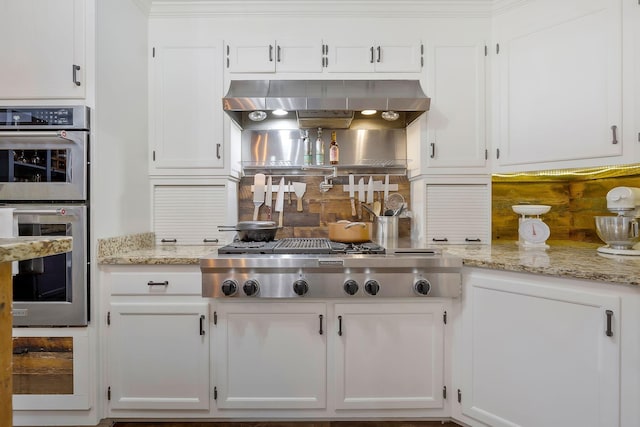 kitchen featuring white cabinetry, extractor fan, light stone counters, and appliances with stainless steel finishes