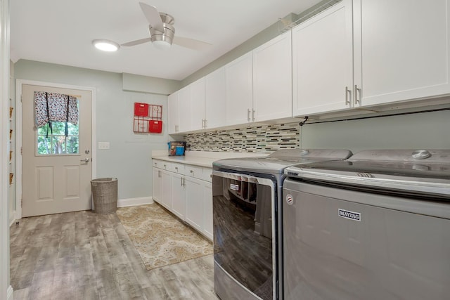 laundry area with ceiling fan, cabinets, separate washer and dryer, and light wood-type flooring