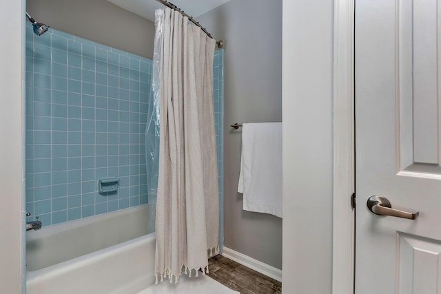 bathroom with hardwood / wood-style floors and shower / bath combo with shower curtain