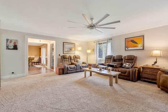 carpeted living room with ceiling fan and crown molding