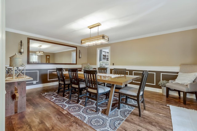 dining area with wood-type flooring and ornamental molding