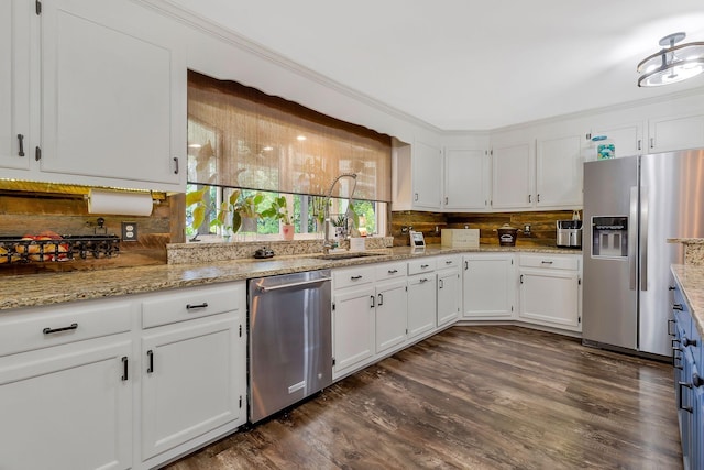 kitchen with dark wood-type flooring, white cabinets, sink, appliances with stainless steel finishes, and tasteful backsplash