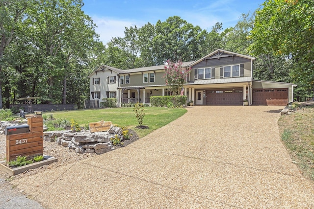 view of front of home featuring covered porch, a garage, and a front lawn