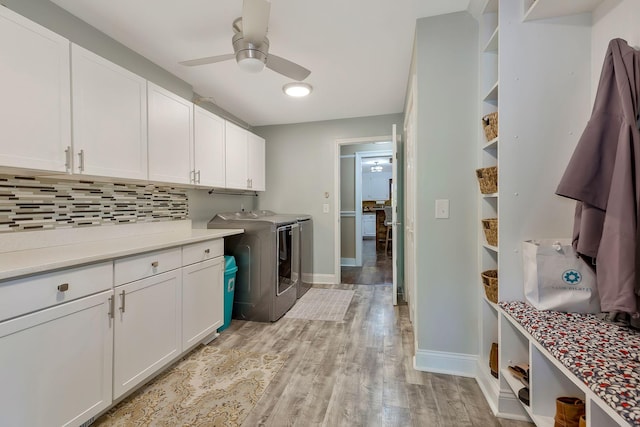 laundry room featuring washer and dryer, ceiling fan, cabinets, and light hardwood / wood-style flooring