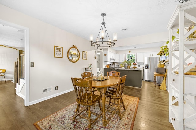 dining area with a notable chandelier and dark hardwood / wood-style floors