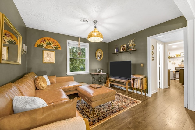 living room featuring wood-type flooring and a textured ceiling