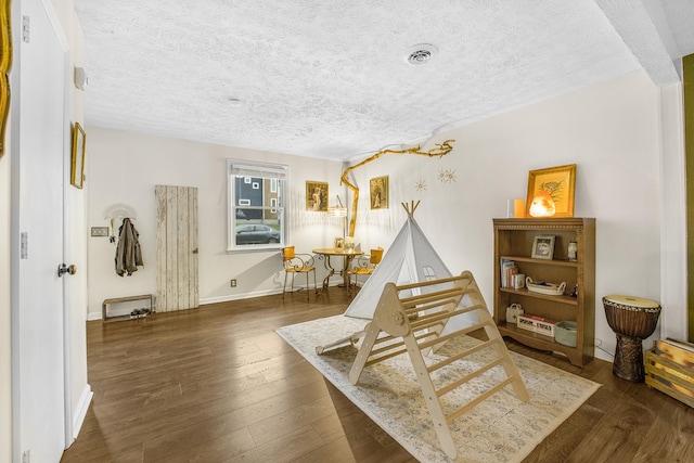 living area with dark hardwood / wood-style flooring and a textured ceiling