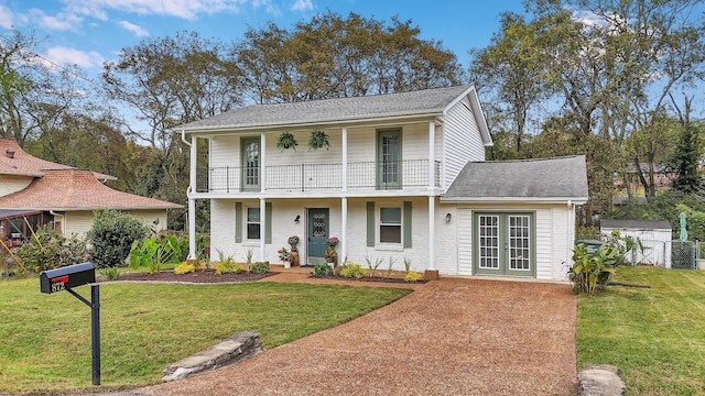 view of front of home featuring a balcony and a front lawn