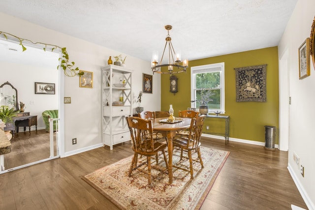 dining space with a notable chandelier, dark hardwood / wood-style floors, and a textured ceiling