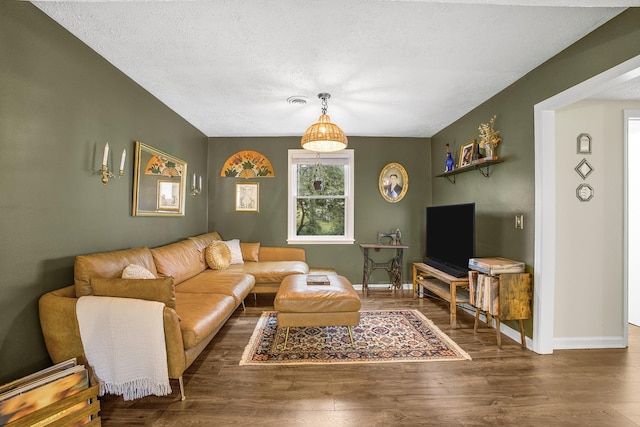 living room with a textured ceiling and dark wood-type flooring